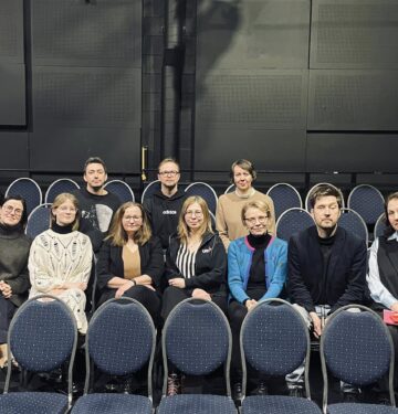 Tumesinistel teatritoolidel istub 10 inimest: 3 tagumises reas ja 7 esimeses reas.